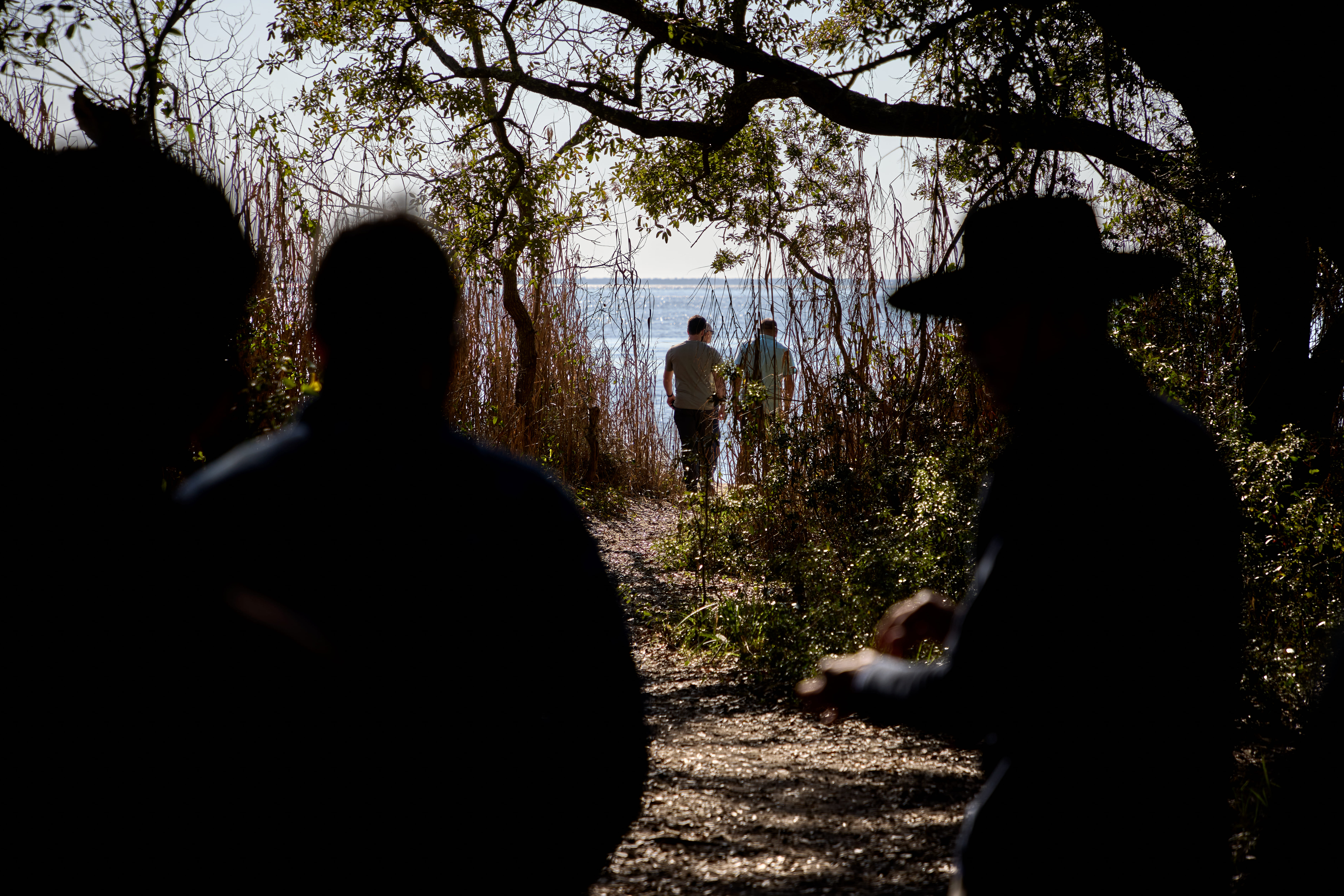 People walking along a trail toward Pensacola Bay